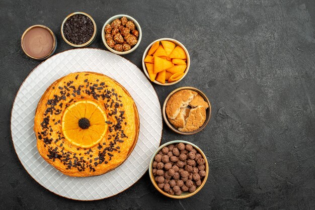 Top view delicious pie with orange slices on dark surface biscuit fruit dessert pie cake tea