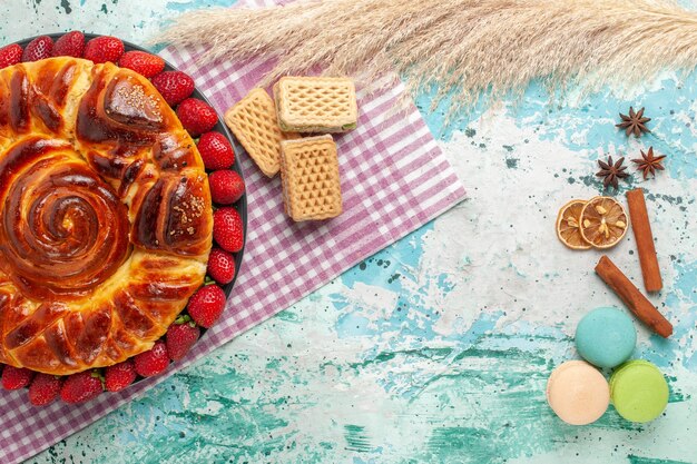 Top view delicious pie with red strawberries and waffles on blue surface