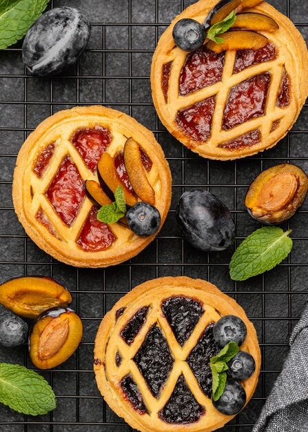 Top view of delicious pies with plums on cooling rack