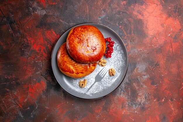 어두운 테이블에 빨간 열매와 상위 뷰 맛있는 파이 달콤한 케이크 파이 파이