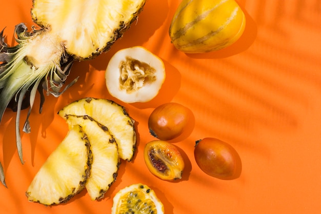 Вид сверху вкусного ананаса и фруктов на столе