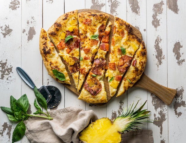 Top view of delicious pizza cut in slices with pineapple