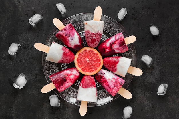 Top view of delicious popsicles with red grapefruit and ice