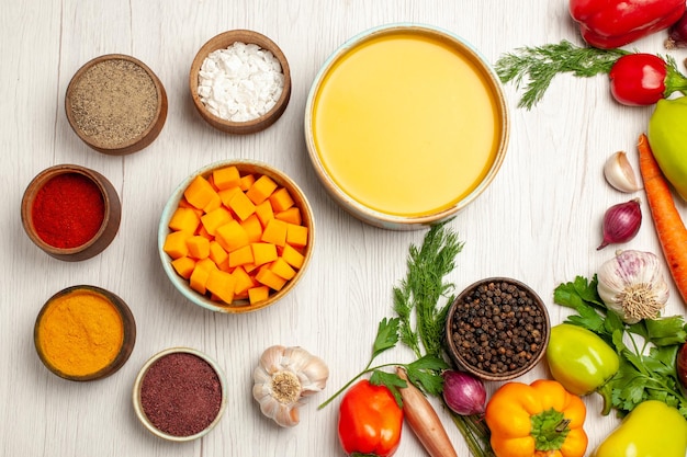 Top view delicious pumpkin soup cream textured with vegetables on the white desk ripe soup sauce meal