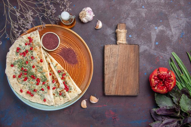 Top view delicious qutabs cooked dough pieces with greens on the dark surface dinner dish cooking dough meal