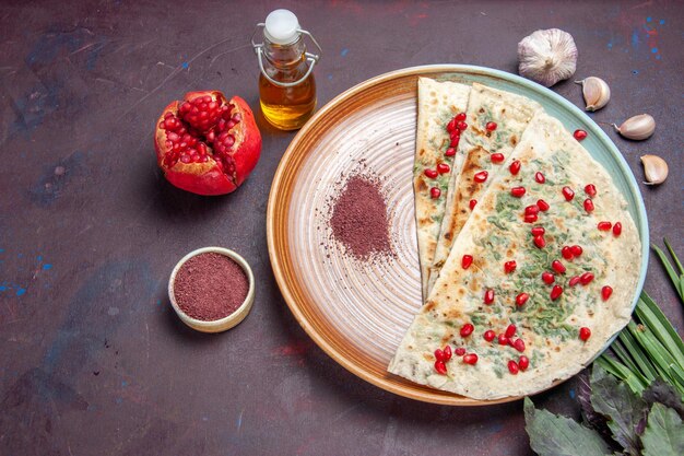 Top view delicious qutabs cooked dough pieces with greens on the dark surface dough meal dinner dish cooking