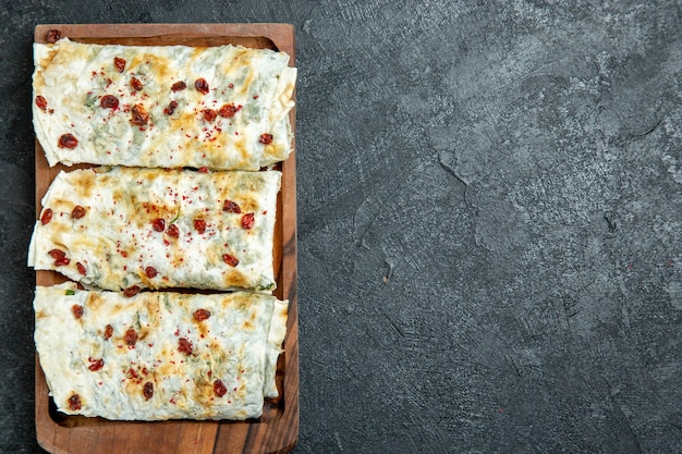 Top view delicious qutabs rolled green filled dough slices on grey space