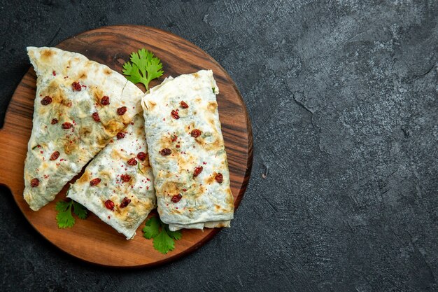 Top view delicious qutabs rolled green filled dough slices on the grey space