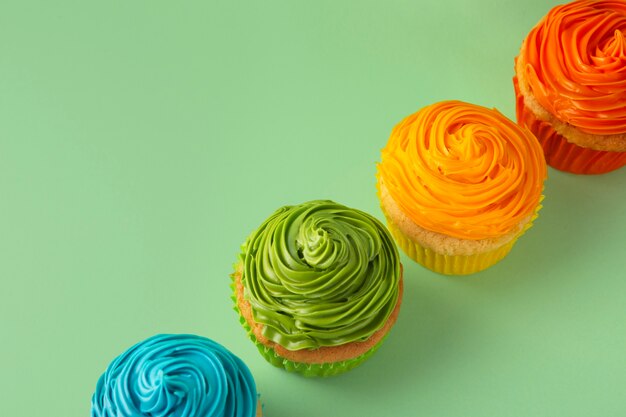 Top view delicious rainbow cupcake glaze still life