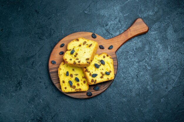 Top view delicious raisin cakes sliced on dark blue space