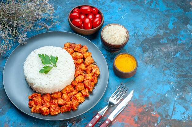 緑とトマトのチキンカトラリーが青いテーブルに塩にんにくトマトをセットしたおいしいご飯の上面図