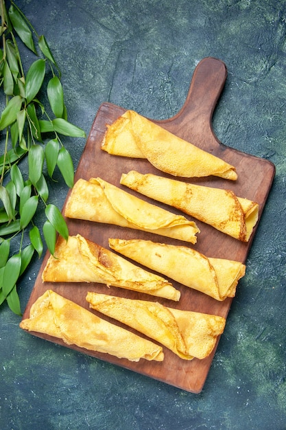 Foto gratuita vista dall'alto deliziose frittelle arrotolate su una superficie scura