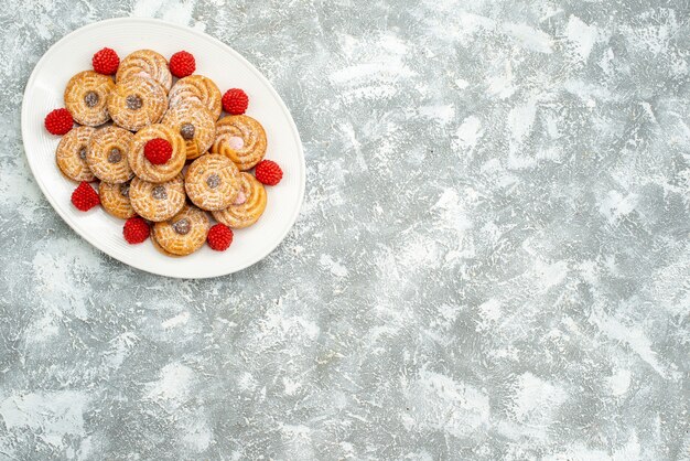Вид сверху вкусного круглого печенья с малиновым конфитюром на белом пространстве
