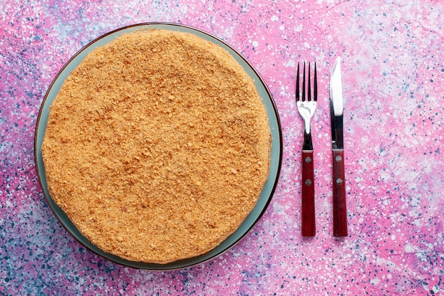 Foto gratuita vista dall'alto deliziosa torta rotonda all'interno della lastra di vetro con posate sulla scrivania luminosa torta torta biscotto dolce cuocere lo zucchero