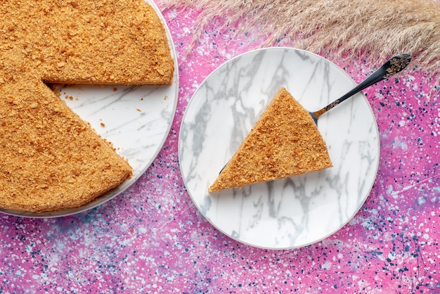 Бесплатное фото Вид сверху вкусный круглый торт внутри тарелки на ярко-розовом столе, пирог, бисквит, сладкая выпечка