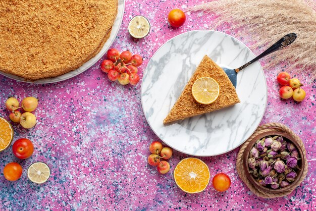 Top view delicious round cake slice of it inside plate on bright-pink floor cake pie biscuit sweet bake