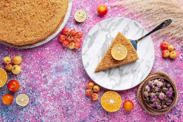 Top view delicious round cake slice of it inside plate on bright-pink floor cake pie biscuit sweet bake