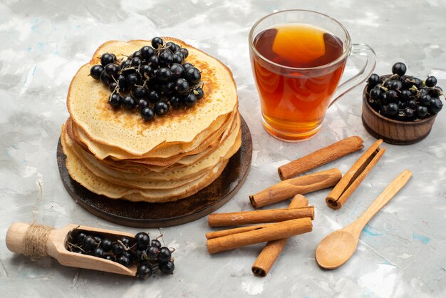 A top view delicious round pancakes yummy and round formed with blueberries and cinnamon on the light desk pancake cooking 