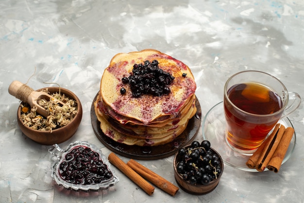 A top view delicious round pancakes yummy and round formed with blueberries tea and cinnamon pancake pastry