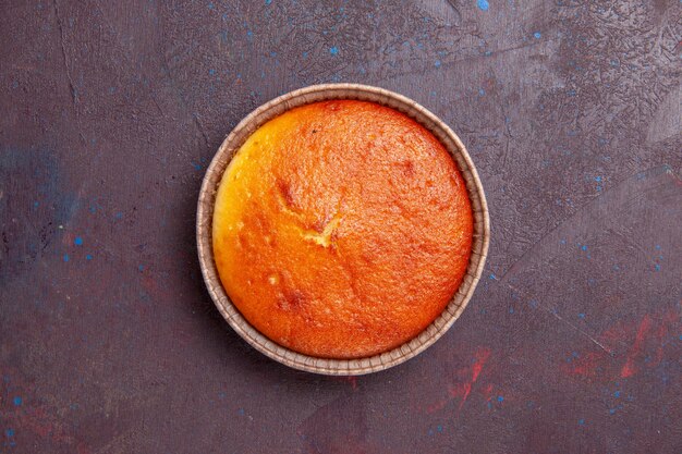 Free photo top view delicious round pie sweet bake on dark background biscuit dough pie cake sugar sweet tea