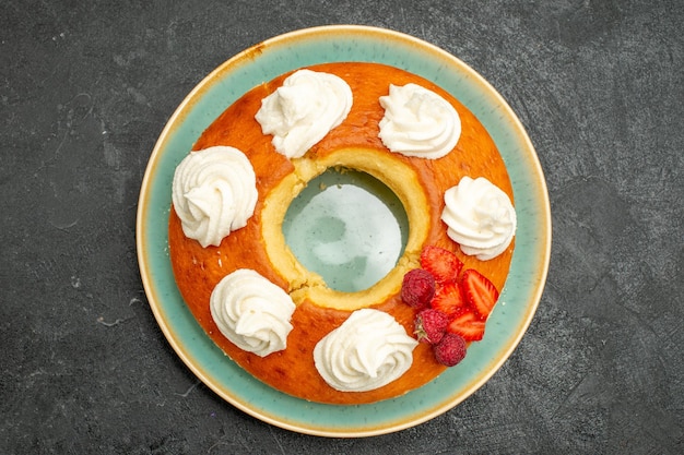 Top view delicious round pie with fruits and cream on a dark background tea sugar cookie biscuit cake pie sweet