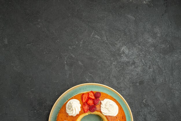 Top view delicious round pie with fruits and cream on dark background tea sugar cookies biscuit cake pie sweet