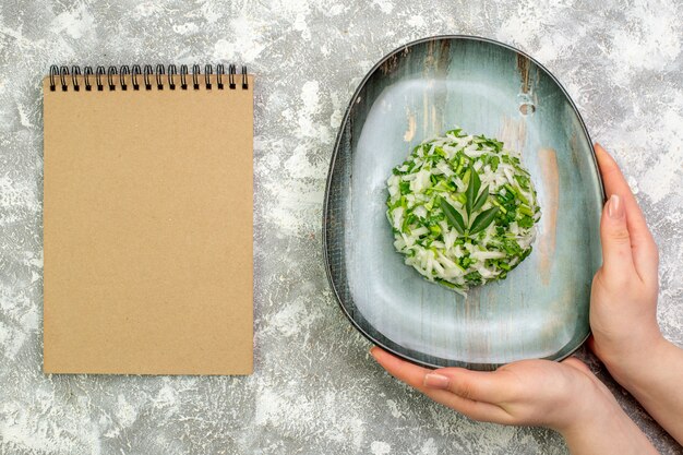 Top view delicious salad consists of greens and cabbage inside plate