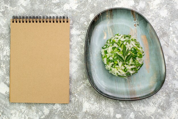 Top view delicious salad consists of greens and cabbage inside plate