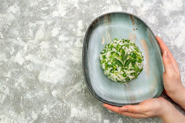 Top view delicious salad consists of greens and cabbage inside plate