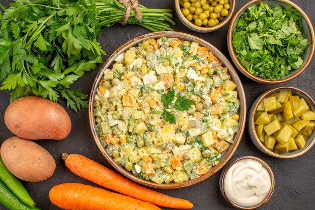 Top view of delicious salad with fresh vegetables on a dark surface