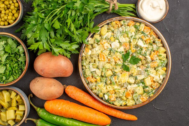 Top view of delicious salad with fresh vegetables on dark surface