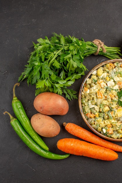 Top view of delicious salad with fresh vegetables on dark surface