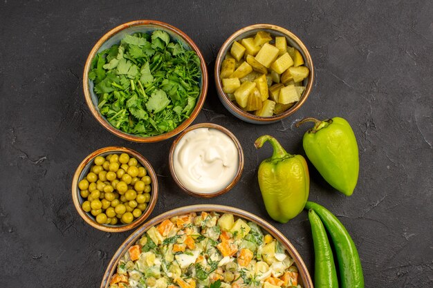 Top view of delicious salad with ingredients on dark surface