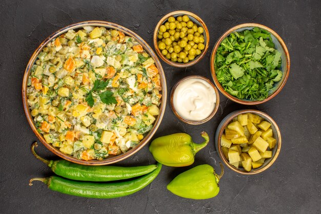 Top view of delicious salad with ingredients on dark surface