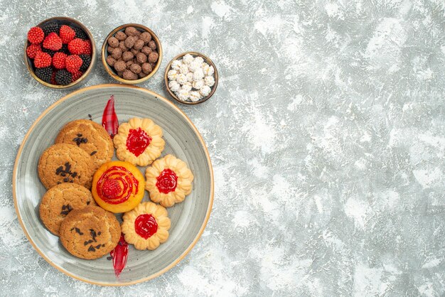 上面図白い背景の上のクッキーとキャンディーとおいしい砂のビスケット砂糖ビスケットケーキクッキーティースイート
