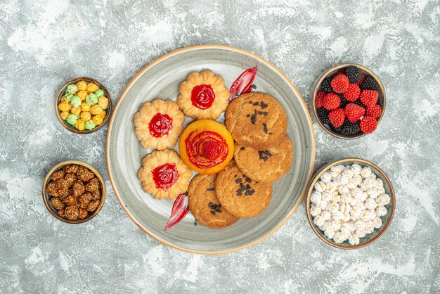 Top view delicious sand biscuits with cookies and candies on white background sugar biscuit cake cookie tea sweet