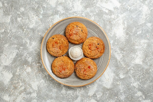 Top view delicious sand cookies inside plate on a white background