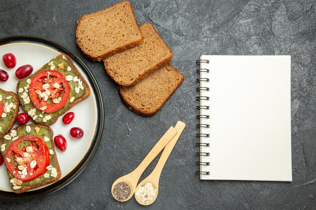 Top view delicious sandwiches with avocado pasta and tomatoes inside plate on the grey background bun burger sandwich snack bread