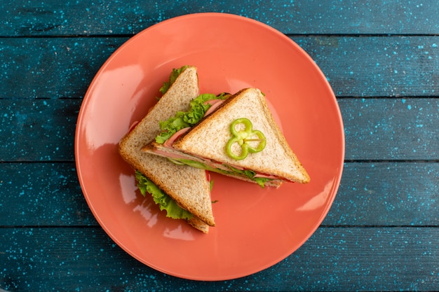 Free photo top view of delicious sandwiches with green salad ham and tomatoes