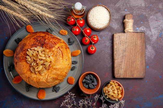 Foto gratuita vista dall'alto delizioso shakh plov cotto pasto di riso con uvetta e pomodori sull'impasto del pasto sfondo scuro cucinare la cena di riso