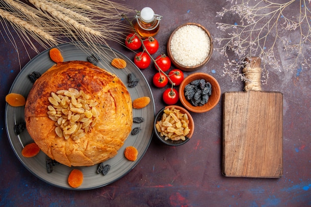 Top view delicious shakh plov cooked rice meal with raisins and tomatoes on dark purple background meal dough cooking rice dinner