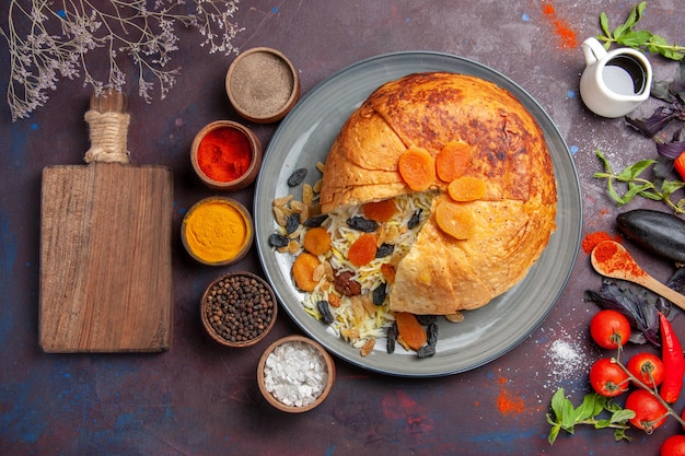 Foto gratuita vista dall'alto del delizioso shakh plov con uvetta e condimenti sulla superficie scura