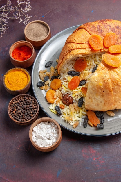 Top view of delicious shakh plov with raisins and seasonings on dark surface