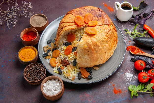 Top view of delicious shakh plov with raisins and seasonings on dark surface