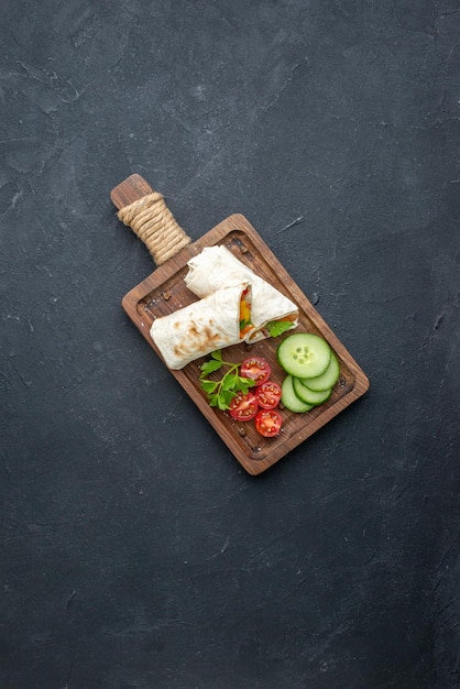 Top view delicious shawarma sliced pita sandwich on cutting board dark surface