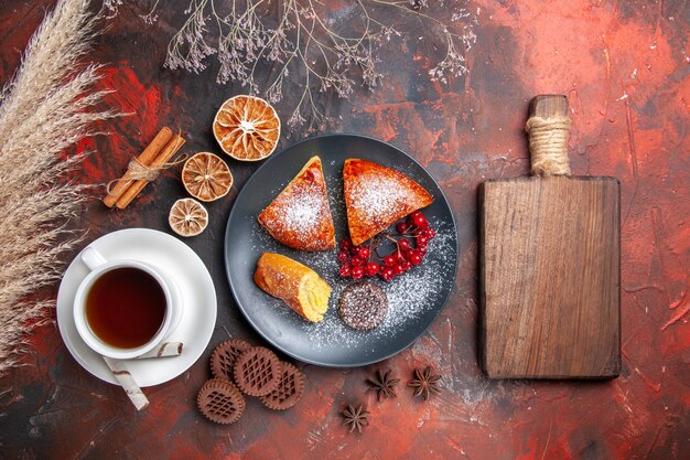 Top view delicious sliced pie with cup of tea on dark floor cake sweet pie tea