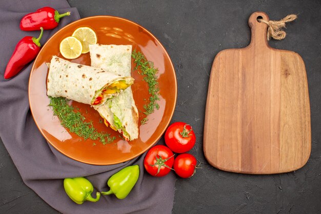 Top view delicious sliced shaurma sandwich with fresh vegetables on a dark background burger meal sandwich snack bread