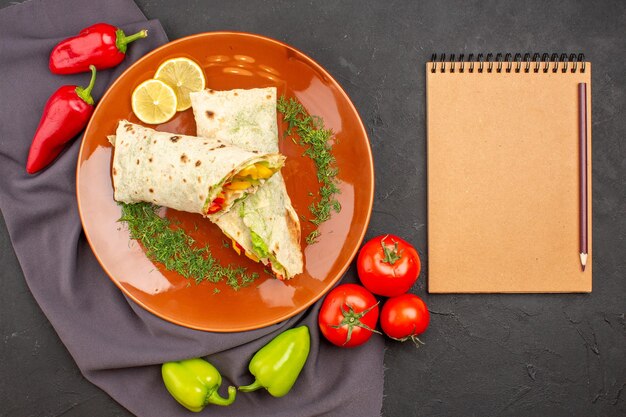 Top view delicious sliced shaurma sandwich with fresh vegetables on the dark background burger meal sandwich snack bread