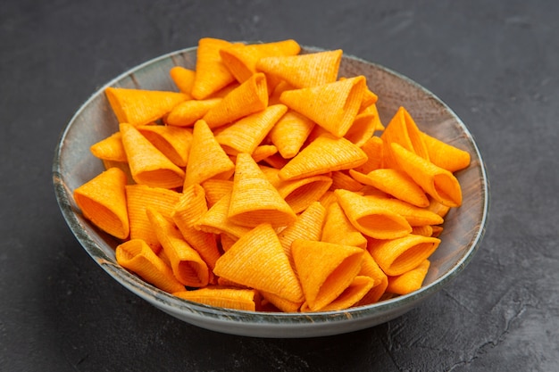 Top view of delicious snacks in a blue bowl on a dark background