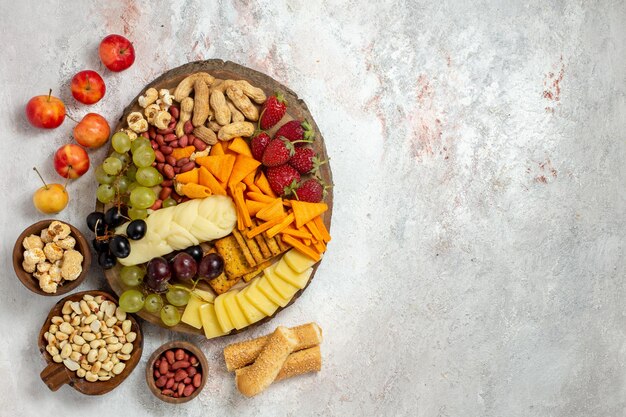 Top view of delicious snacks cips grapes cheese and nuts on light white surface